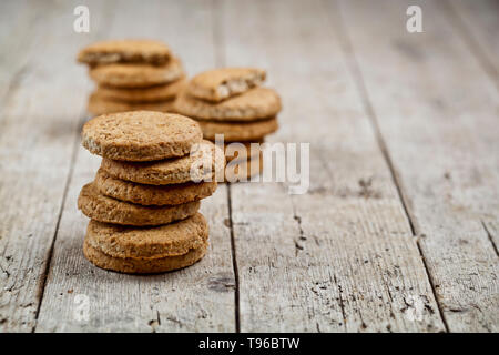 Stacks of fresh baked oat cookies on rustic wooden table background. With copy space. Stock Photo