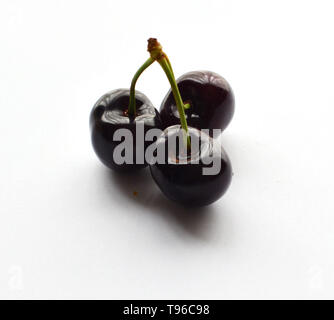 Three cherries joined together on a white background Stock Photo