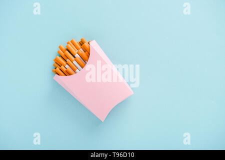 top view of cigarettes packed in paper box isolated on blue with copy space, french fries concept Stock Photo