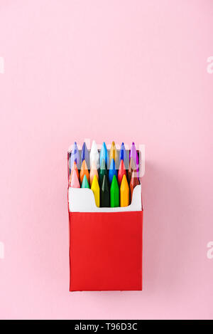 crayons in cigarette box top view of multicolored crayons in red cigarette pack on pink with copy  space, smoking concept Stock Photo