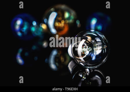 Retro light bulb with reflection on black table Stock Photo