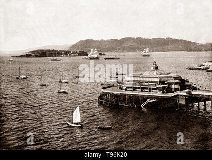 A late 19th Century view of yachts and sailing beyond the promenade pier, opened in 1884, in Plymouth, a port city situated on the south coast of Devon, England.  Enclosing the city are the mouths of the river Plym and river Tamar, which are naturally incorporated into Plymouth Sound to form a boundary with Cornwall. Stock Photo