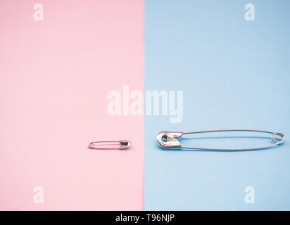 Two safety pins representing a man and a woman. Concept of machismo and feminism Stock Photo