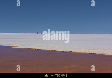 Driving through the endless flat on the vast salt flats of Salar de Uyuni, Bolivia Stock Photo