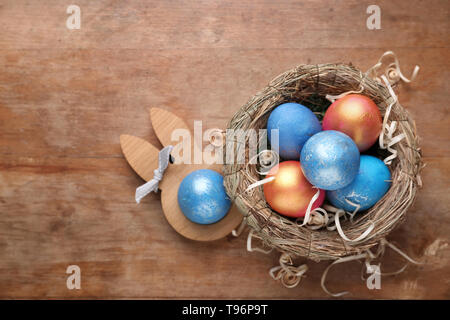 Nest with Easter eggs on wooden background Stock Photo