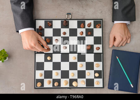 Businessman playing chess on grey table Stock Photo