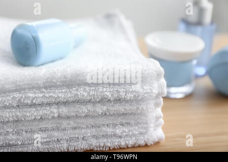 Folded white terry towels on table indoors Stock Photo