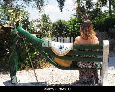 Woman tourist sitting on bench in the Avant-garden at the Dali Museum in St. Petersburg, Florida, USA, May 8, 2019, © Katharine Andriotis Stock Photo