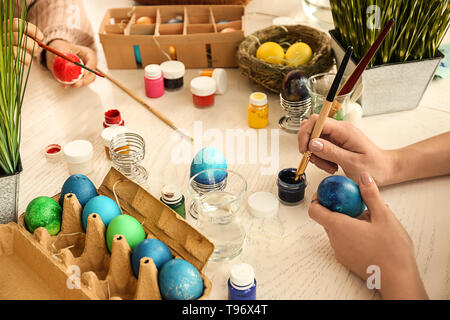 Women painting Easter eggs on table Stock Photo