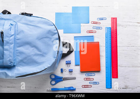 Composition with rucksack and school stationery on light background, top view Stock Photo