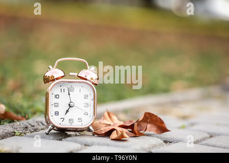 Alarm clock on ground outdoors Stock Photo