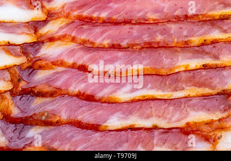 Close-up of appetizing slices of smoked bacon. With baking paper. Stock Photo