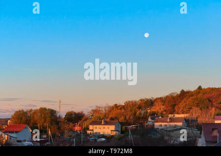 dawn and the moon in the sky, the dawn hours in the village in the spring Stock Photo