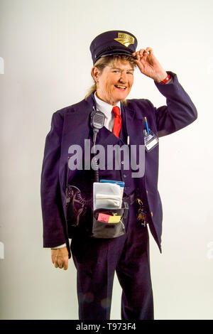 A friendly uniformed woman railroad conductor poses with her equipment at the Los Angeles train yards. Stock Photo