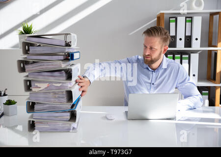 Businessperson Pushing Paper Documents Away And Working With Digital Documents On Computer Instead Stock Photo