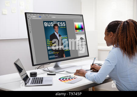 Young Female Designer Editing Photos On Computer In Office Stock Photo