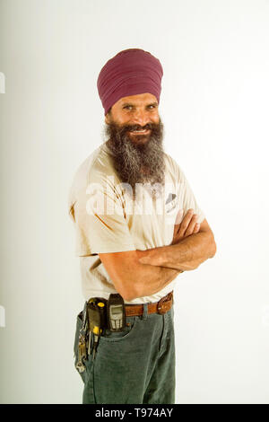 A turban-wearing Sikh railroad maintenance worker poses at the Los Angeles train yards. MODEL RELEASE Stock Photo