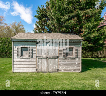an old shed sitting in a green yard Stock Photo