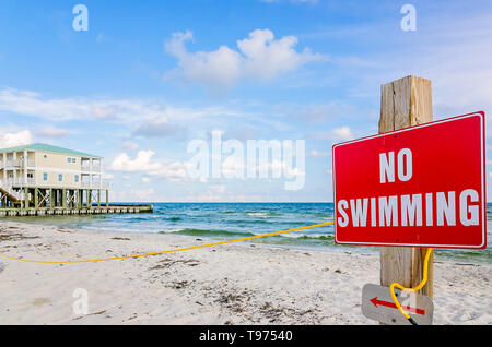 A “no swimming” sign warns visitors to stay out of the water due to rough surf, June 8, 2015, in Dauphin Island, Alabama. Stock Photo
