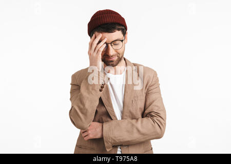 Photo of bearded man 30s wearing hipster hat smiling and touching his forehead isolated over white background Stock Photo