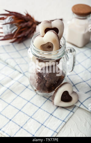 Heart shaped glass jar with ice and bourbon whiskey with a glass rabbit ...