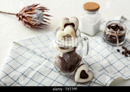 Heart shaped glass jar with ice and bourbon whiskey with a glass rabbit ...