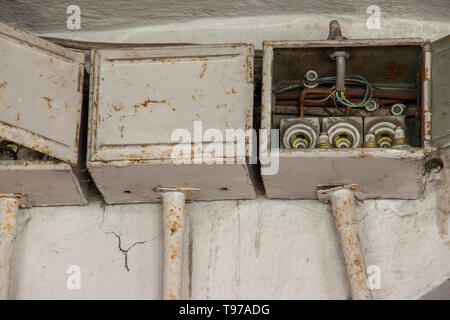 three old electrical boxes on wall Stock Photo