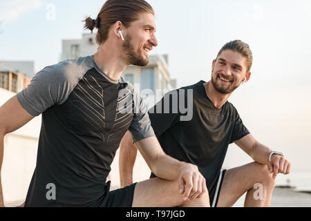 Two twin brothers doing exercises at the beach together Stock Photo