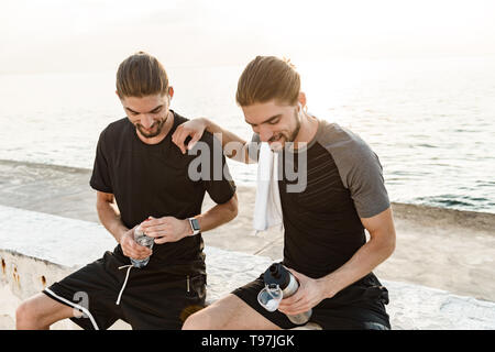 Two twin brothers doing exercises at the beach together Stock Photo
