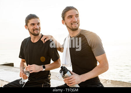 Two twin brothers doing exercises at the beach together Stock Photo