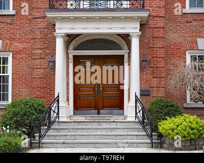 elegant double wooden front door of large suburban house with portico Stock Photo