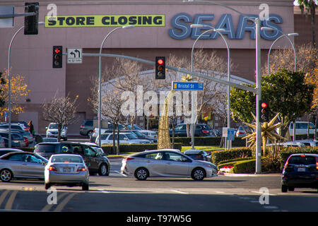 A sign announces the closing of a suburban Sears department store on a busy street in Costa Mesa, CA. Stock Photo