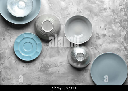 Bowls and plates on grey background Stock Photo