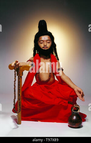 PORTRAIT OF A YOUNG BOY DRESSED AS A SADHU MEIDTATING & LEVITATING Stock Photo