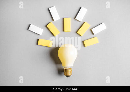 Creative composition with light bulb and color blocks on grey background Stock Photo