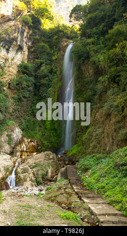 Waterfall on the way to Annapurna circuit, covered with green bushes and trees Tal Nepal Stock Photo