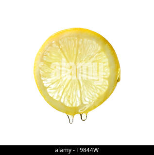 Essential oil dripping from lemon slice on white background Stock Photo