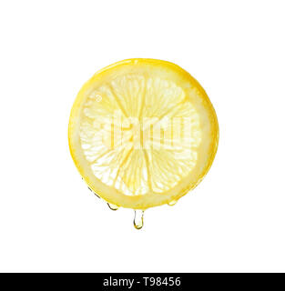 Essential oil dripping from lemon slice on white background Stock Photo