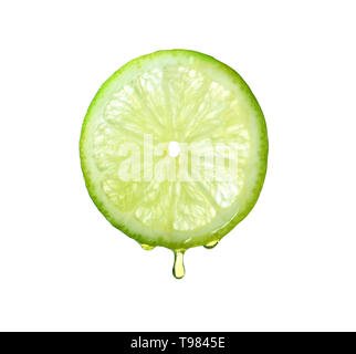 Essential oil dripping from lime slice on white background Stock Photo