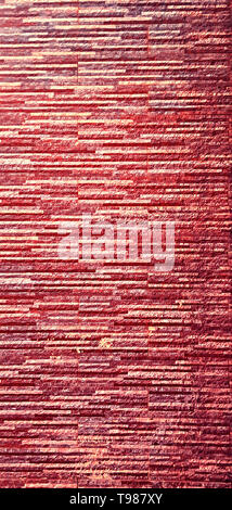 Picturesque, colorful and elegant facing of the wall of the fence, made of bonded thin plates of artificial granite, marble or other stone-forming mat Stock Photo
