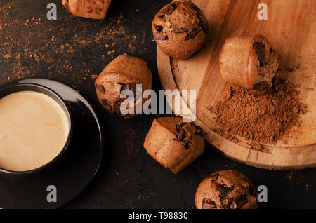 Tray with tasty muffins and cup of coffee on black table Stock Photo