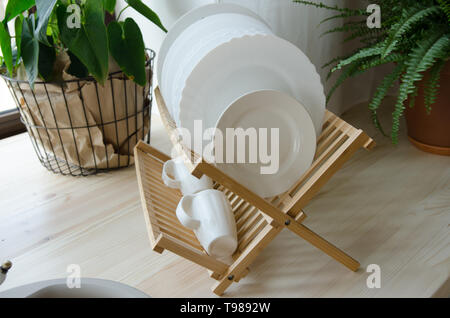 Clean dishes drying on wooden dish rack Stock Photo