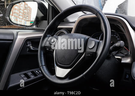 View to the black color interior of suv car with front seats, steering wheel and dashboard  with gray leather upholstery after cleaning and detailing  Stock Photo