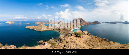 Tourists observing the Panoramic view from the top of Padar Island in Komodo National park in autumn, a protected area which is a paradise for diving, Stock Photo