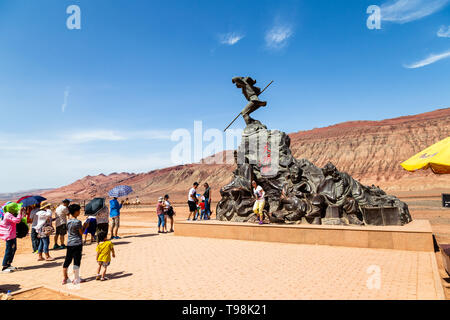 Aug 2017, Flaming Mountains, Xinjiang, China: tourists near a statue from a scene of the Chinese epic Journey to the west when the monkey king and his Stock Photo