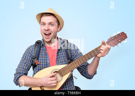 Young tourist man playing guitar and singing Stock Photo