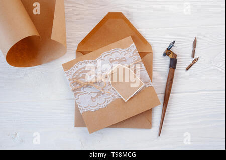 Mockup holiday letter Blank paper and an envelope with pen on wood table, with space for your text, top view Stock Photo