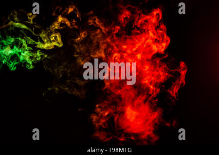 Beautiful horizontal column of smoke in the neon bright light of red, green, yellow and orange on a black background exhaled out of the vape. Nice pat Stock Photo