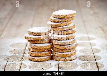 Fresh oat cookies stacks with sugar powder closeup on rustic wooden table background. Stock Photo