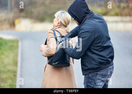 Thief stealing purse from a purse Stock Photo